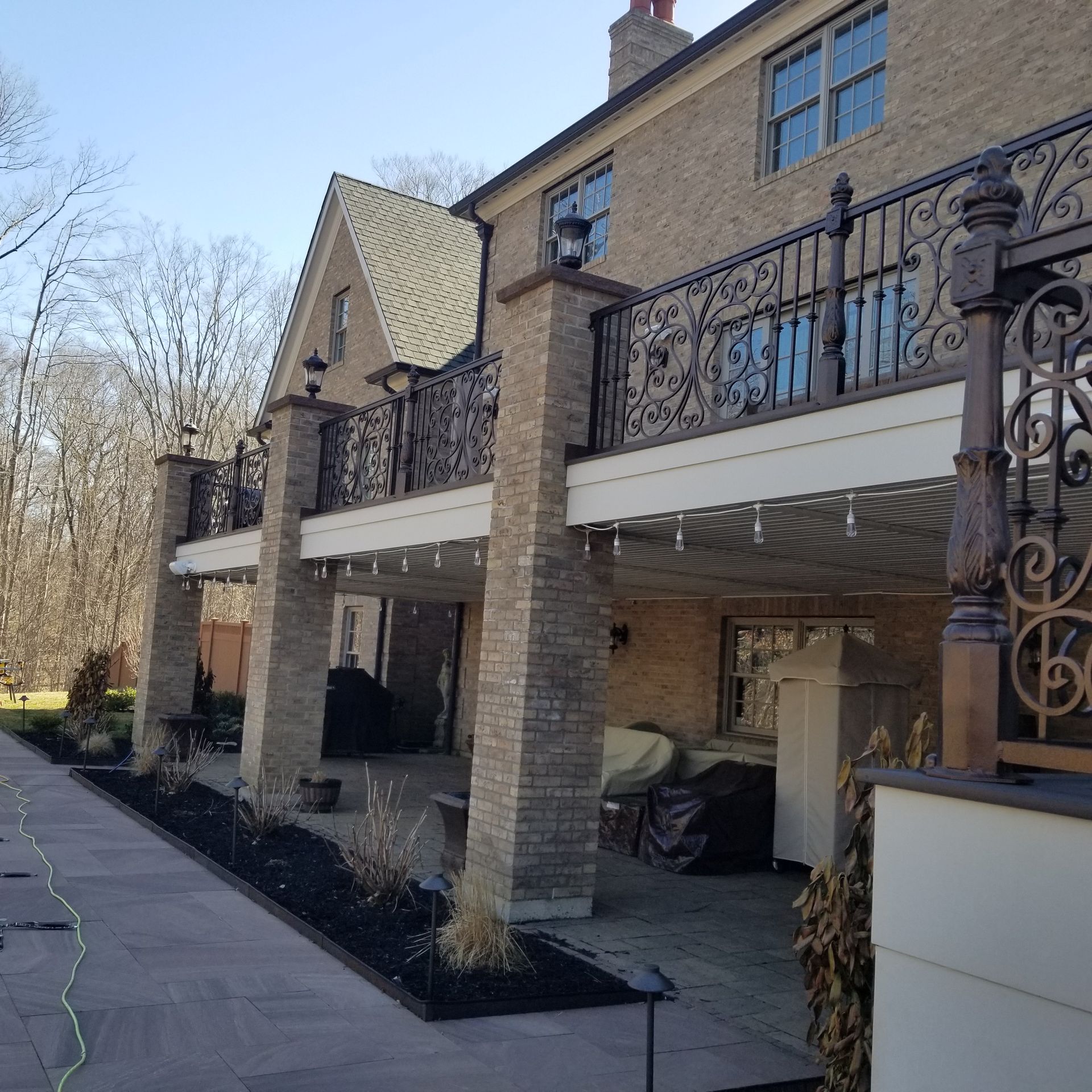 a brick house with a balcony and a wrought iron railing