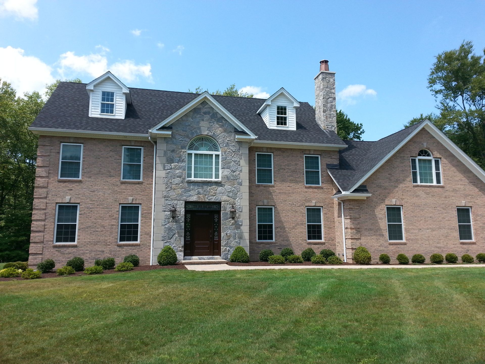 a large brick house with a blue sky in the background