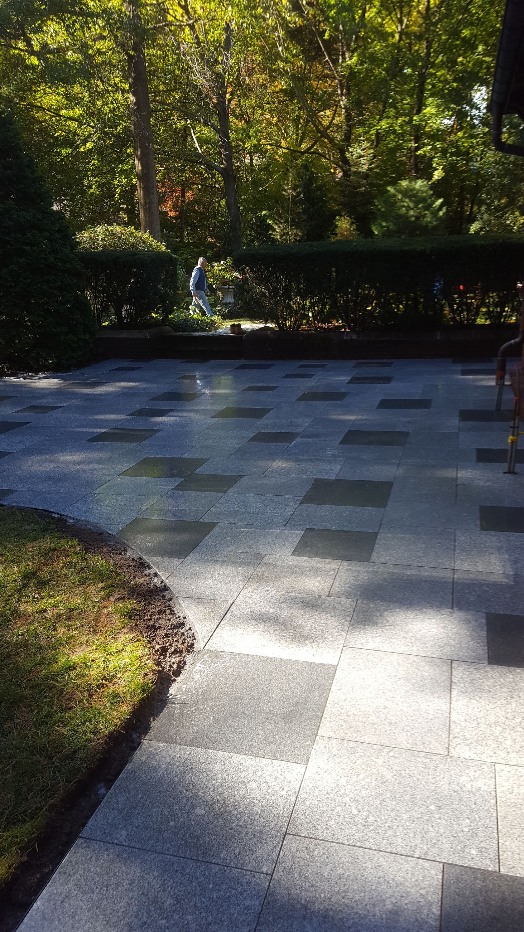 a patio with a checkered pattern and trees in the background