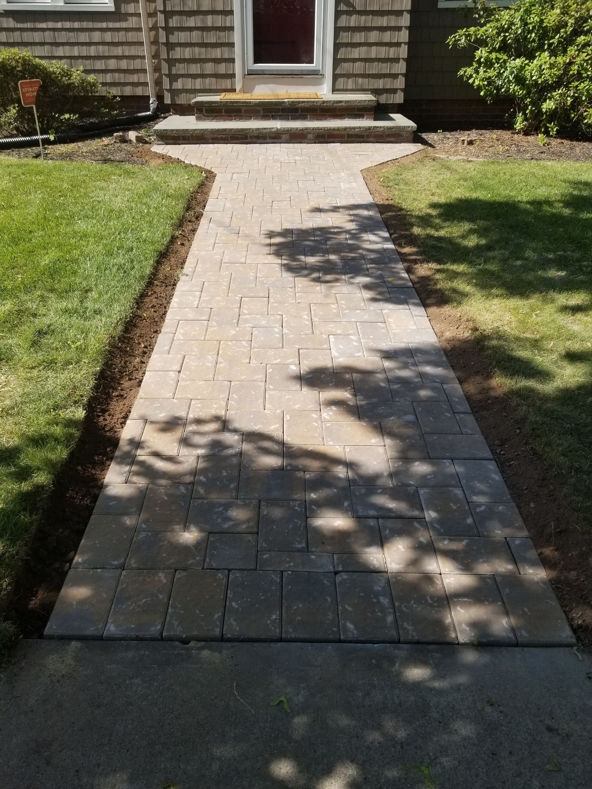 a brick walkway leading to the front door of a house