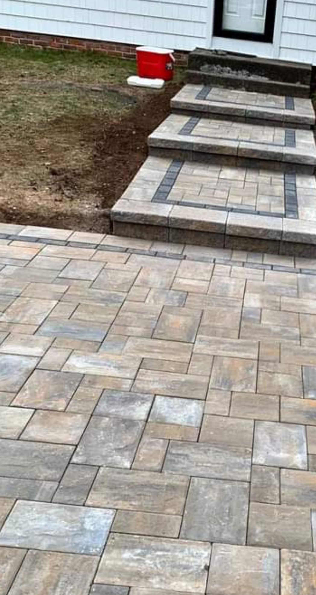 a brick walkway with stairs leading up to a house