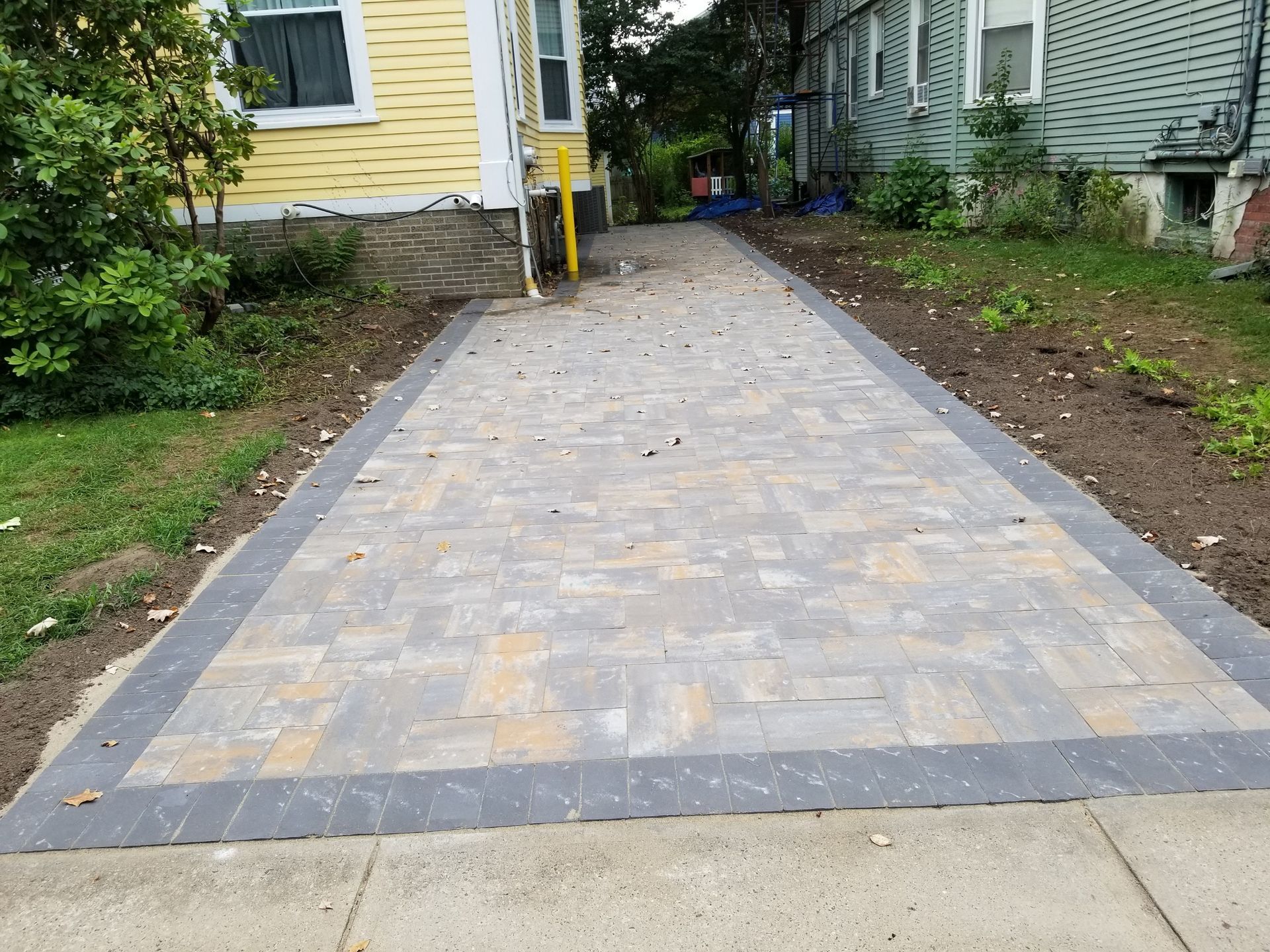 a brick driveway is being built in front of a house