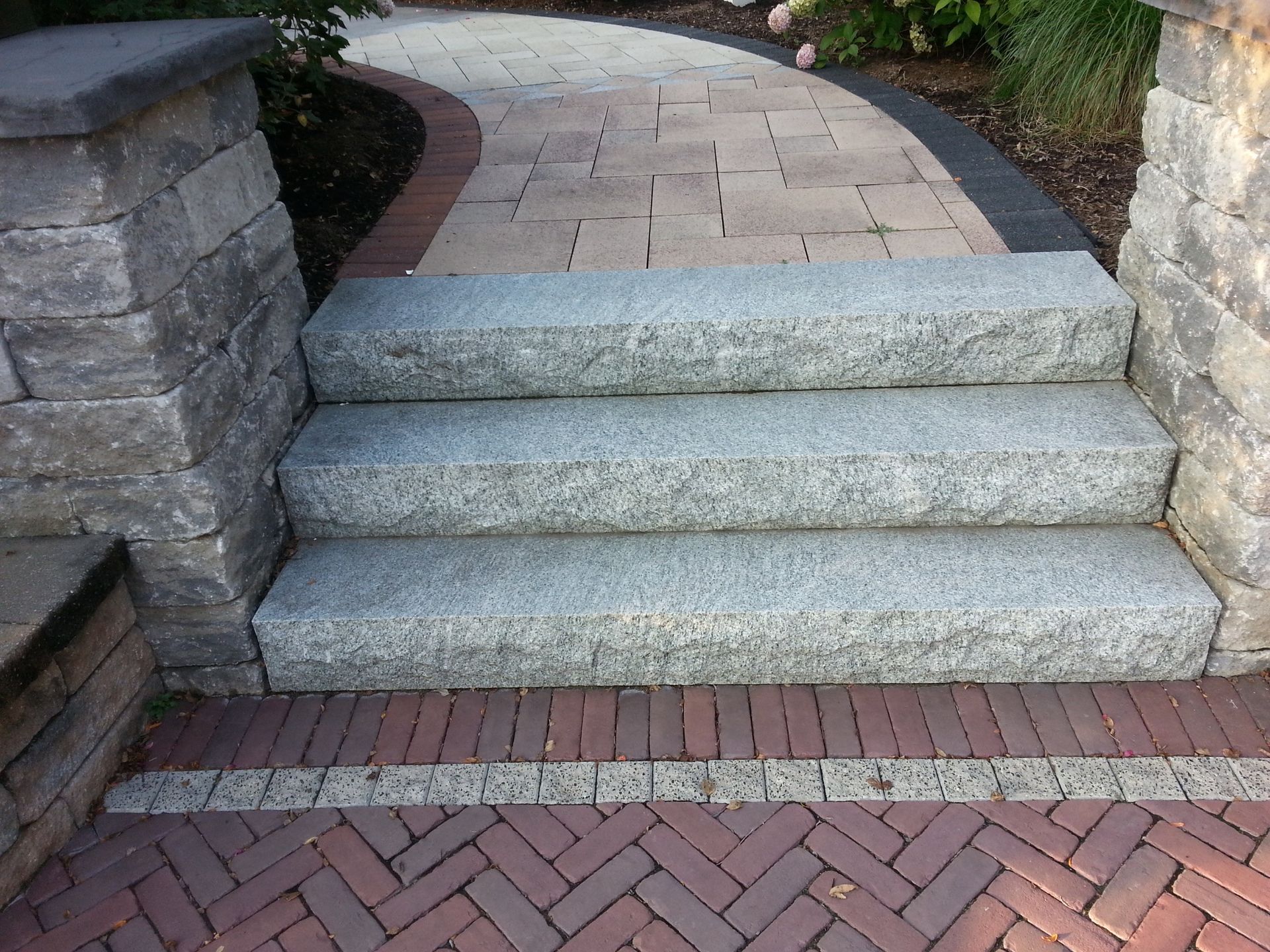 a set of stairs leading up to a brick walkway
