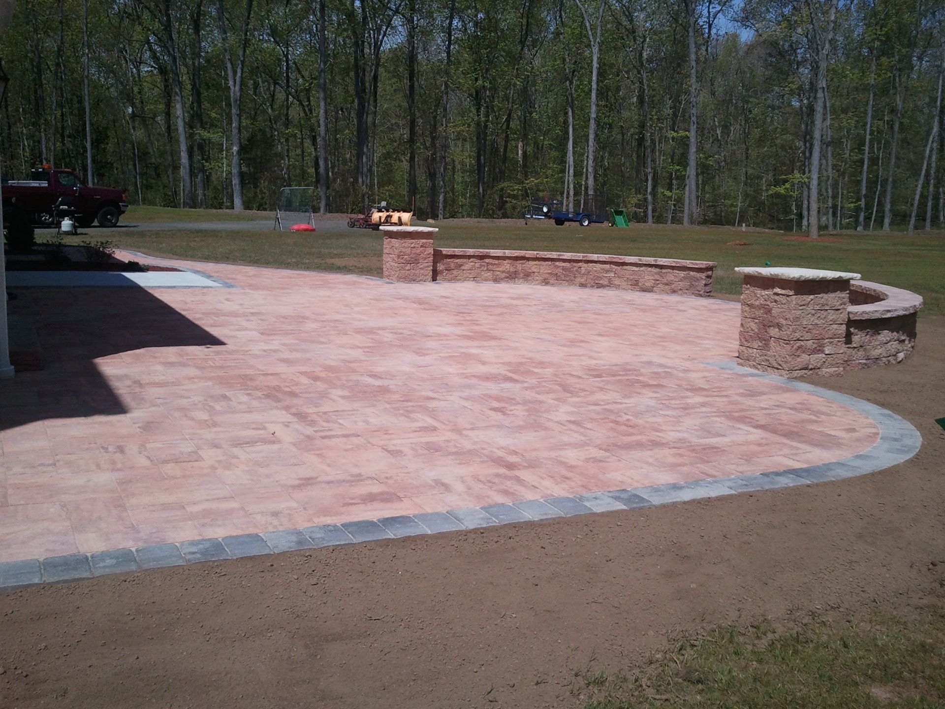 a brick patio with a stone wall in the middle of it