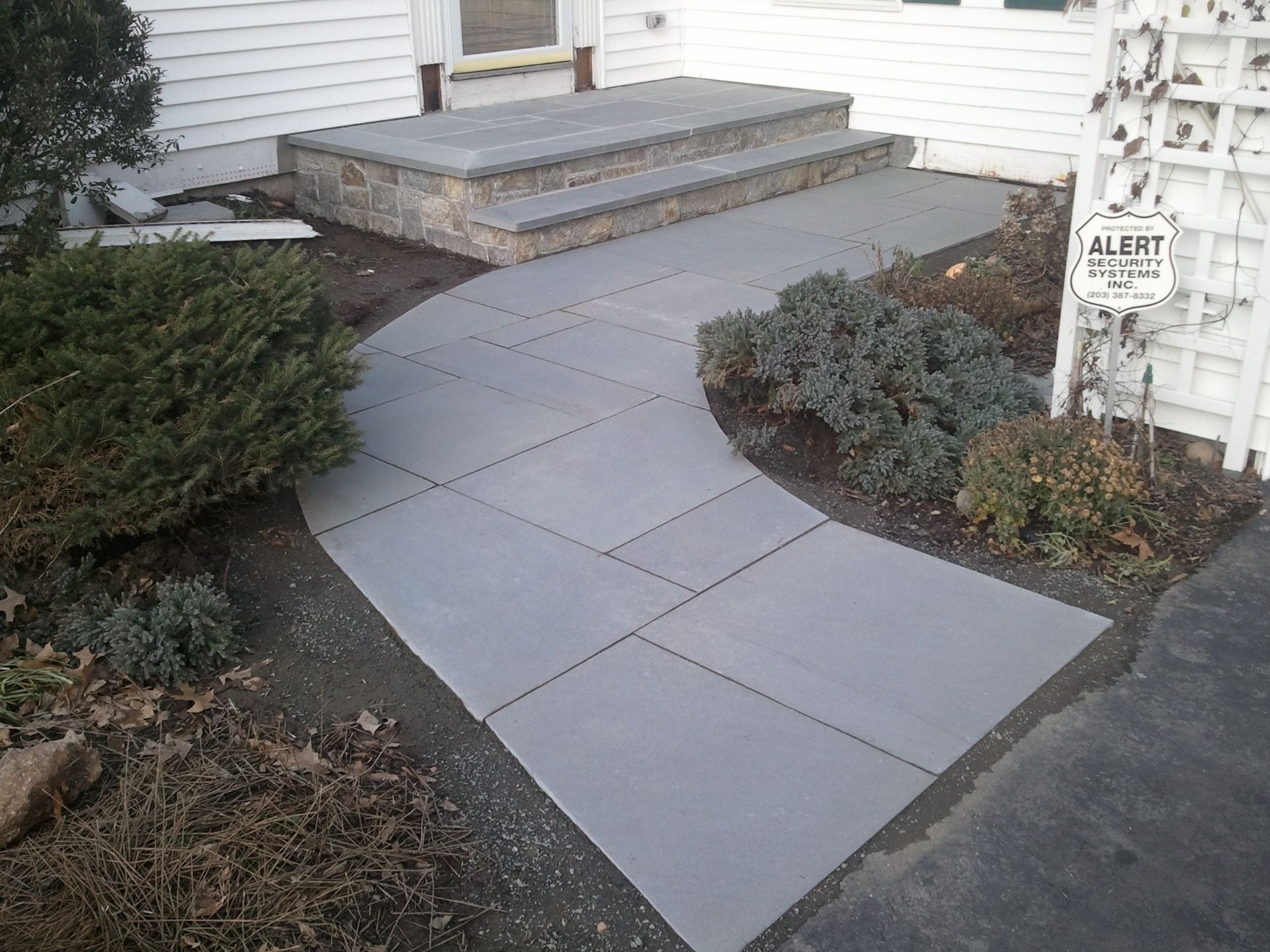 a concrete walkway leading to the front door of a house