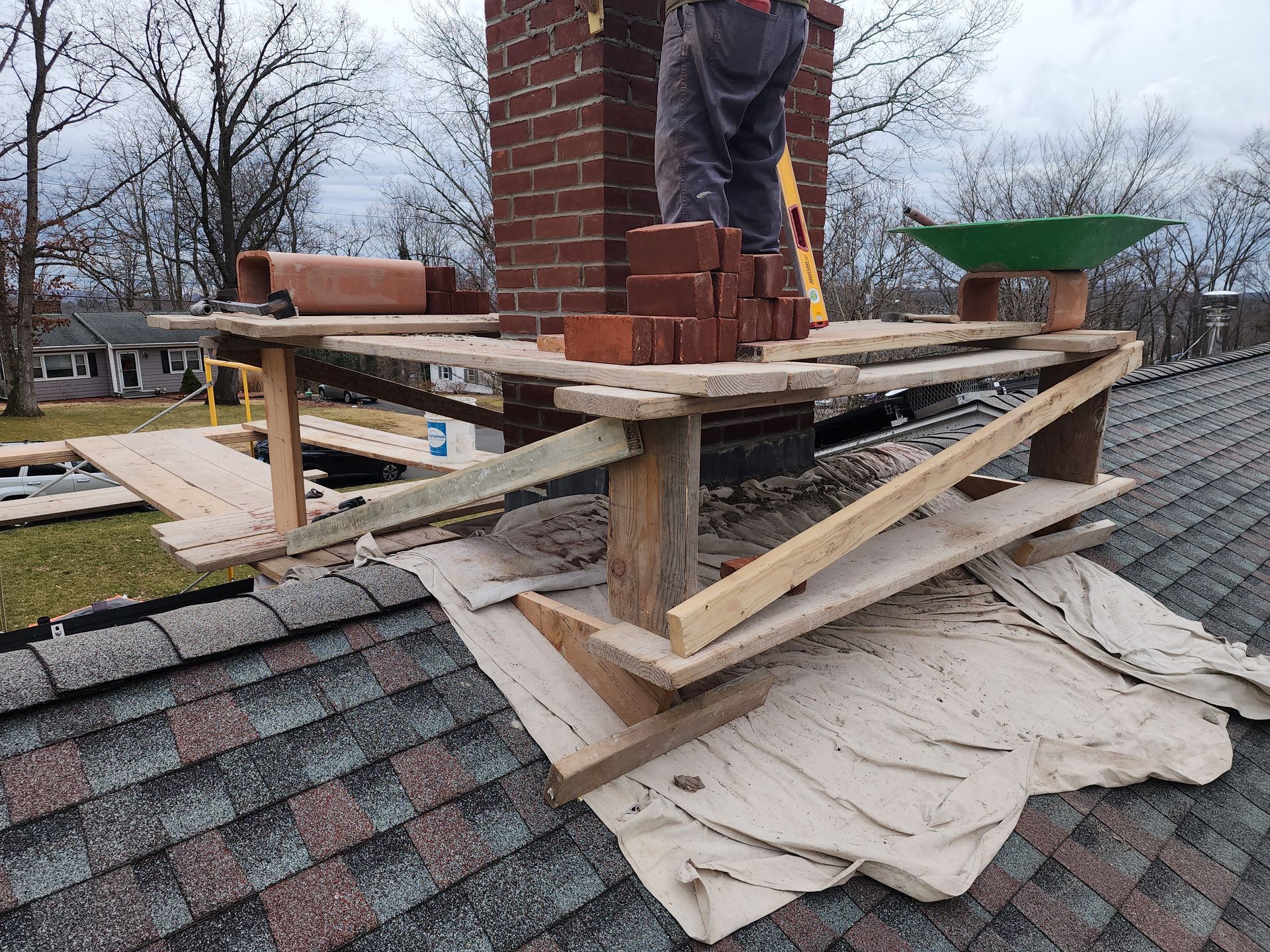 a brick chimney is being built on top of a roof