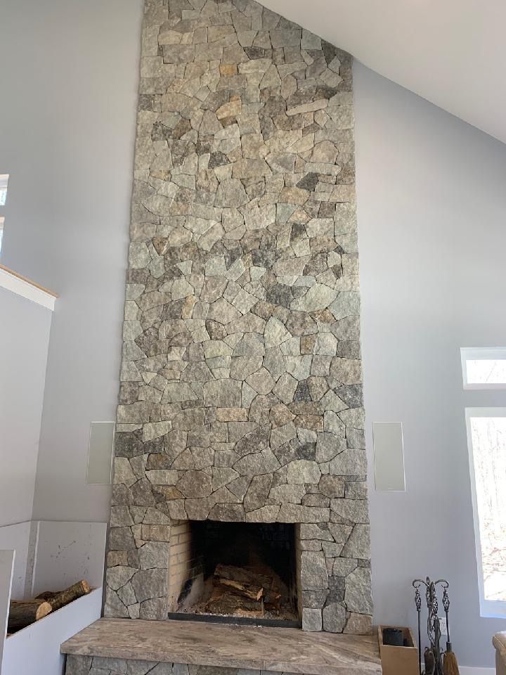 a large stone fireplace in a living room with a vaulted ceiling