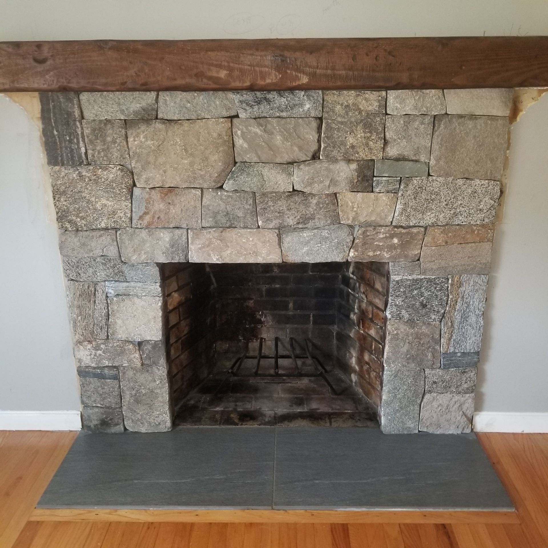 a stone fireplace with a wooden mantle in a living room