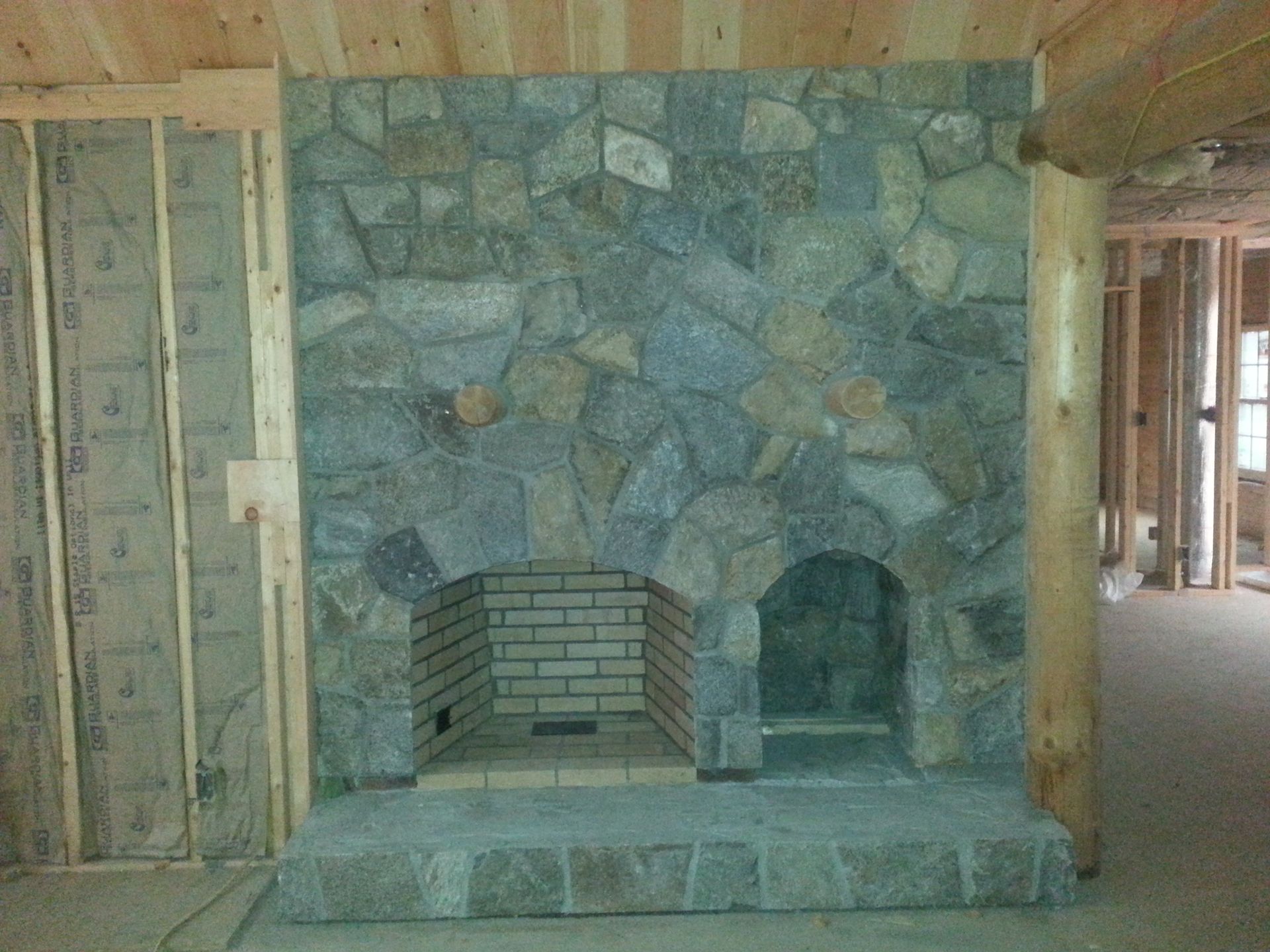 a stone fireplace in a room under construction