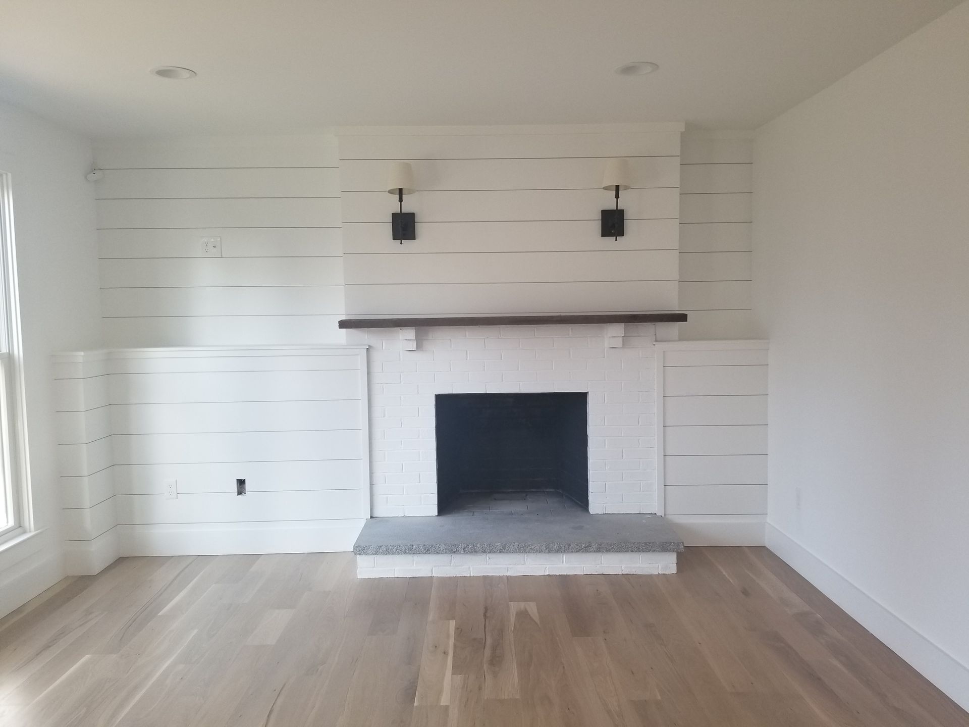 a living room with white walls and a fireplace