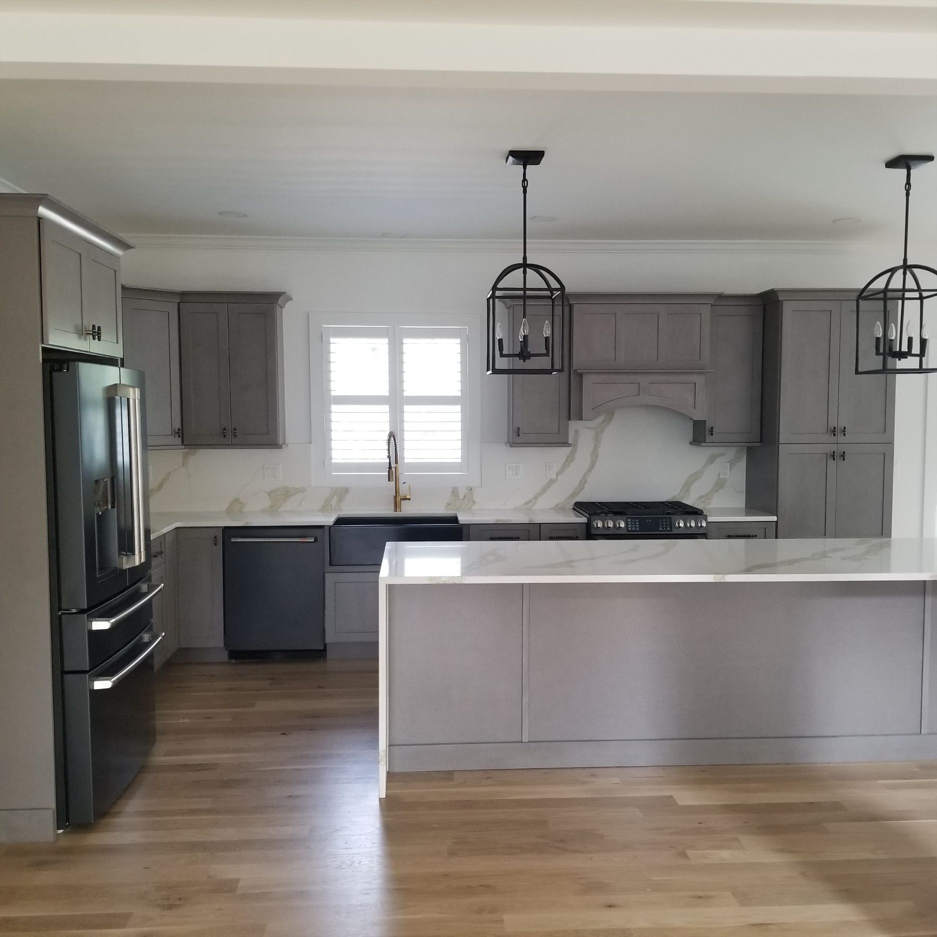 a kitchen with gray cabinets and a large island in the middle