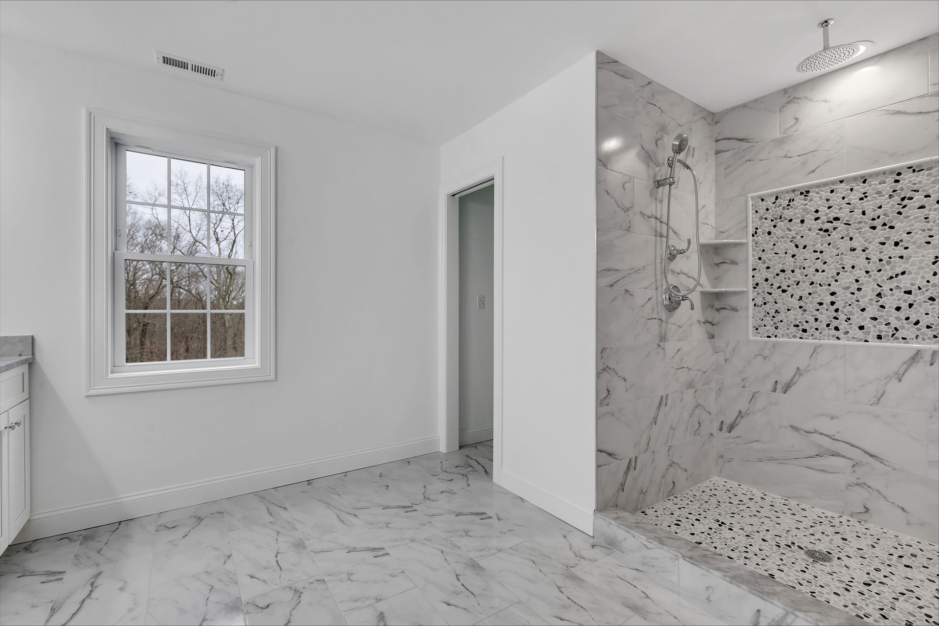a bathroom with a walk in shower and a window