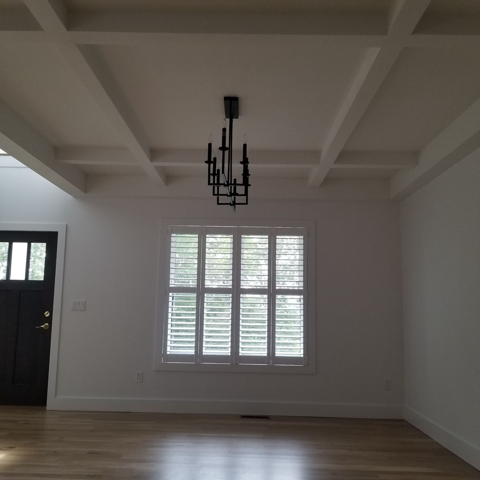 an empty room with a chandelier hanging from the ceiling