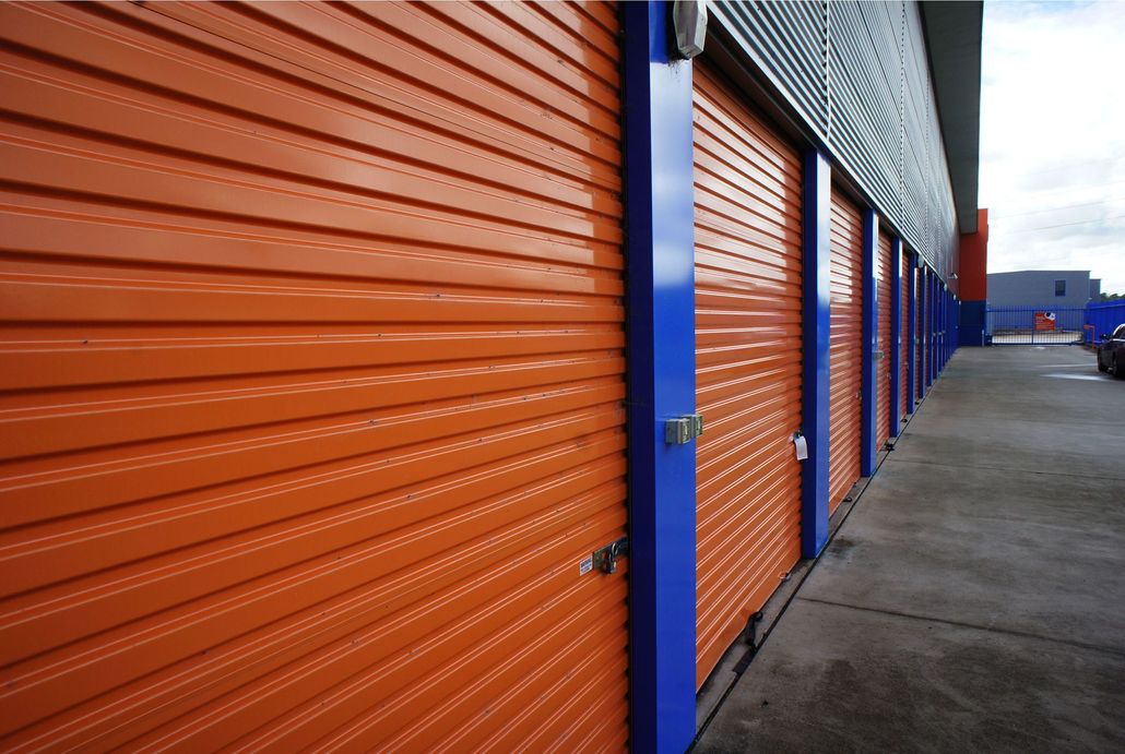 Orange and blue storage unit doors on a building exterior.