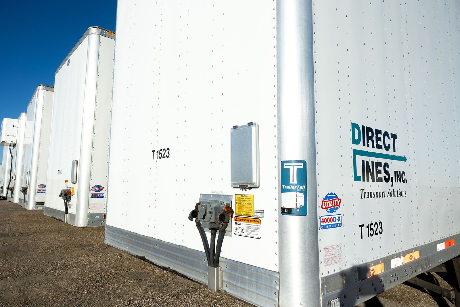 White semi-trailer trucks parked in a row