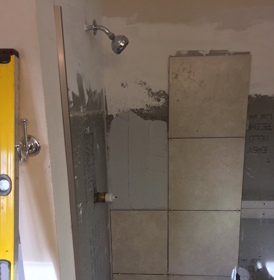 Newly installed show with ceramic tiled up wall