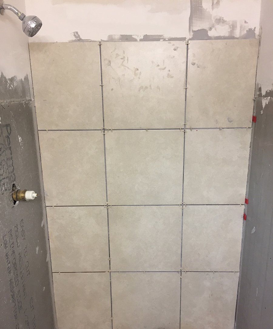 Newly installed show with ceramic tiled up wall