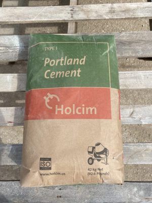 Bag of Holcim Portland Cement on a wooden pallet, green and red packaging