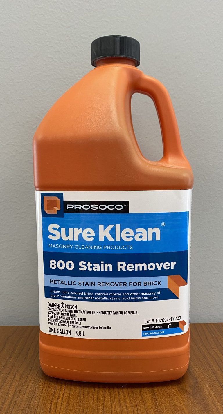 Orange bottle of Sure Klean 600 Stain Remover on a wooden surface