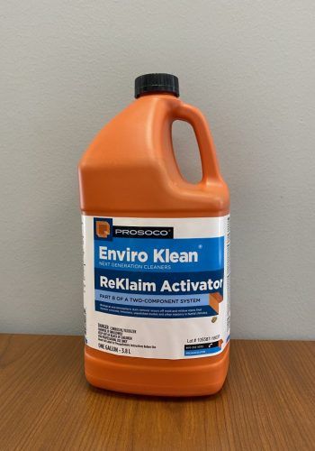 Orange jug of Enviro Klean Rocalm Activator on a wooden table against a plain wall