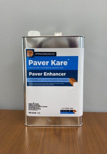 Bottle of Paver Kare paver enhancer in a clear container on a wooden table.