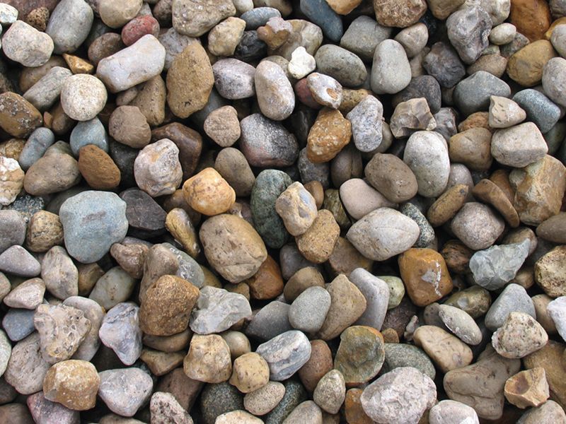 Pile of small rounded pebbles in gray, tan, and brown tones
