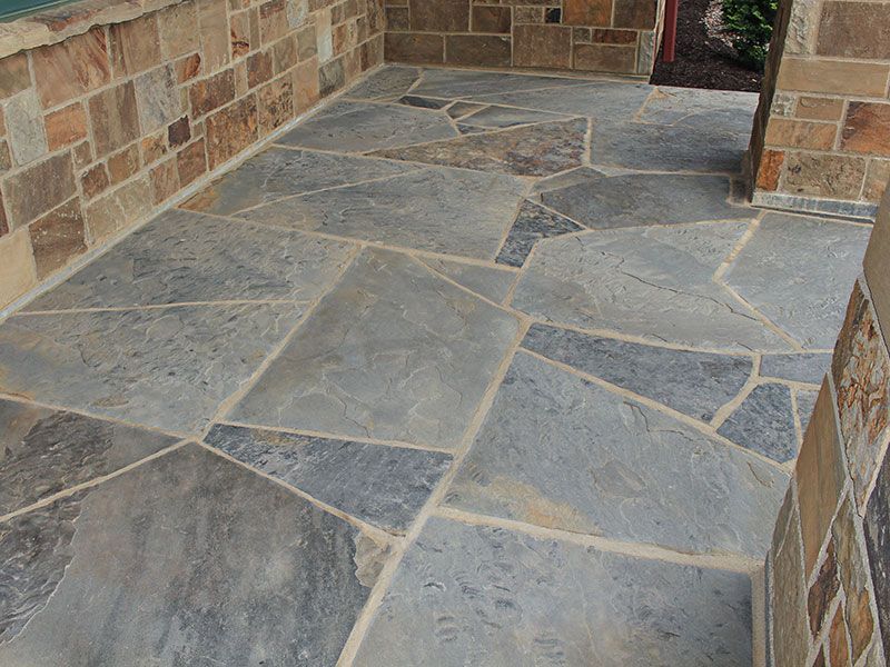 Stone flagstone walkway leading to a brick house entrance