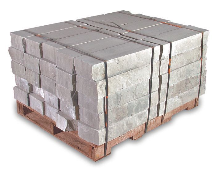 A pallet of stacked, rectangular, light-gray stone blocks secured with black plastic straps.