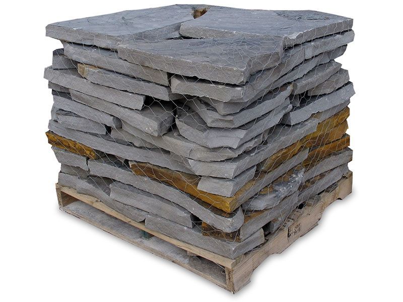 A pallet stacked high with uneven, flat gray and tan natural stone slabs for landscaping or masonry.