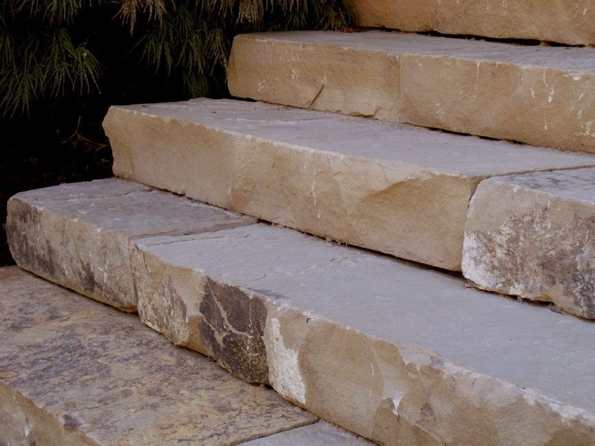 Stone steps leading upward, featuring a natural, rugged texture and earthy, tan tones.