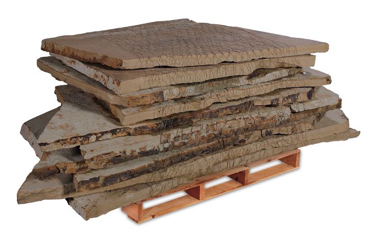 A pallet stack of flat, rustic brown sandstone slabs with rough, natural edges.