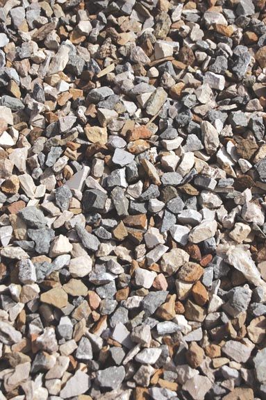 A close-up view of small, multi-colored gravel stones in various shades of gray, white, and tan.