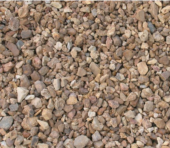 A textured ground cover of small, angular tan, brown, and grey gravel stones packed closely together.