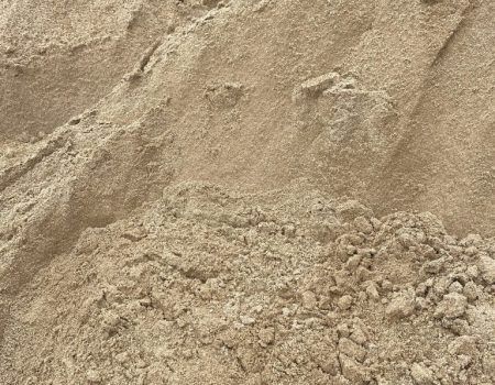Pile of tan sand with rough, textured surface in close-up view