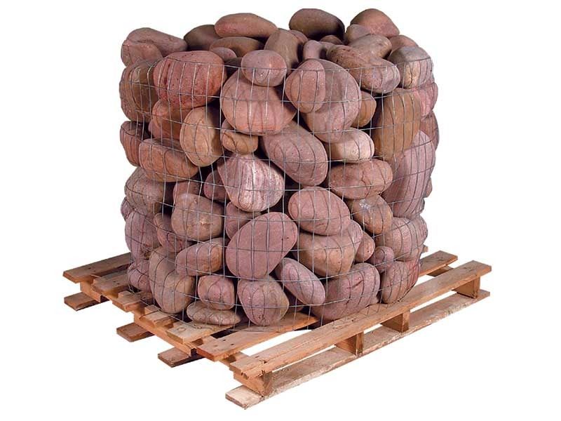A pallet stacked with brown coconuts wrapped in netting.