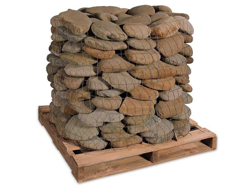 Stacked river rocks on a wooden pallet, forming a wall-like bundle.
