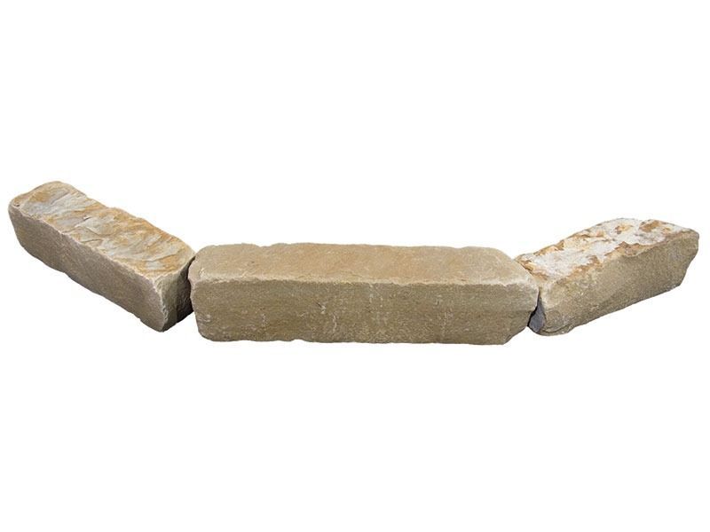 Three beige stone blocks arranged in a shallow V shape on a white background