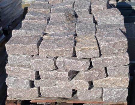 Stacked gray stone blocks on a pallet, viewed close up