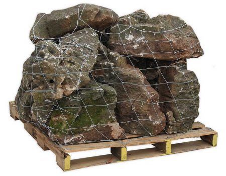 Large stack of brown rocks secured with netting on a wooden pallet