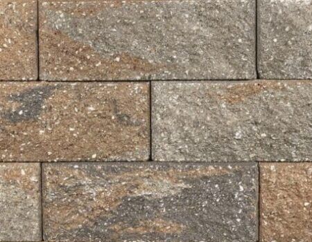 Close-up of stacked tan and gray stone masonry blocks with rough textured surfaces.