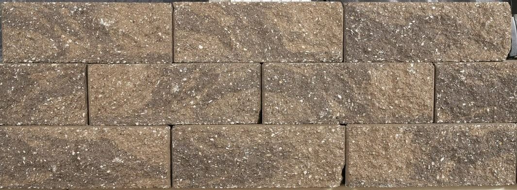 Brown and tan stone brick wall with a rough textured surface