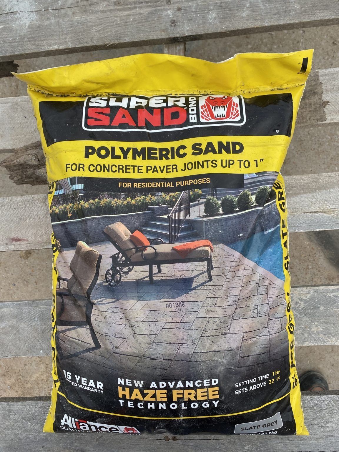 Yellow bag of Super Sand polymeric sand for filling concrete paver joints.