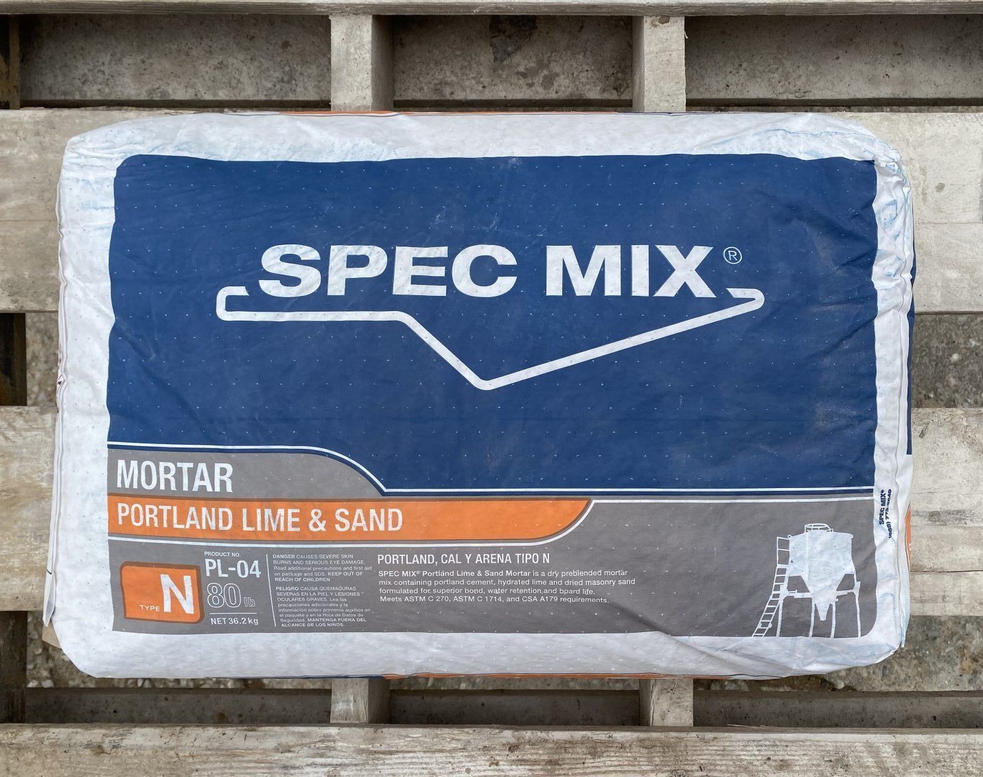 Blue SPEC MIX mortar bag labeled Portland lime & sand on a pallet outdoors.