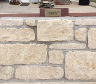 Stone wall with a brass plaque on a brick ledge in an outdoor setting