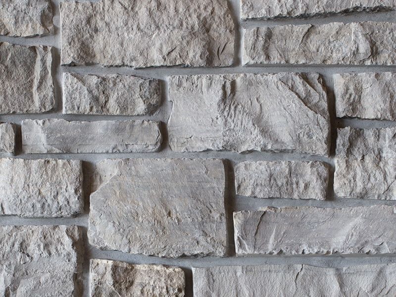 Gray stone wall with irregular stacked blocks and rough texture