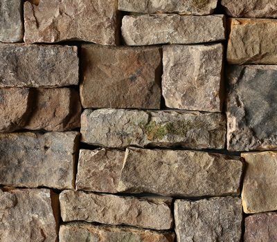Stacked rustic stone wall in earthy brown and gray tones