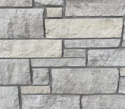 Gray stacked stone wall with rectangular blocks and dark mortar lines