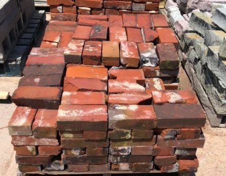 Stacks of red clay bricks piled outdoors on a pallet