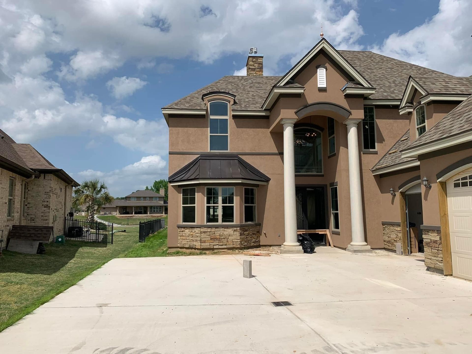 A large house with a concrete driveway in front of it.