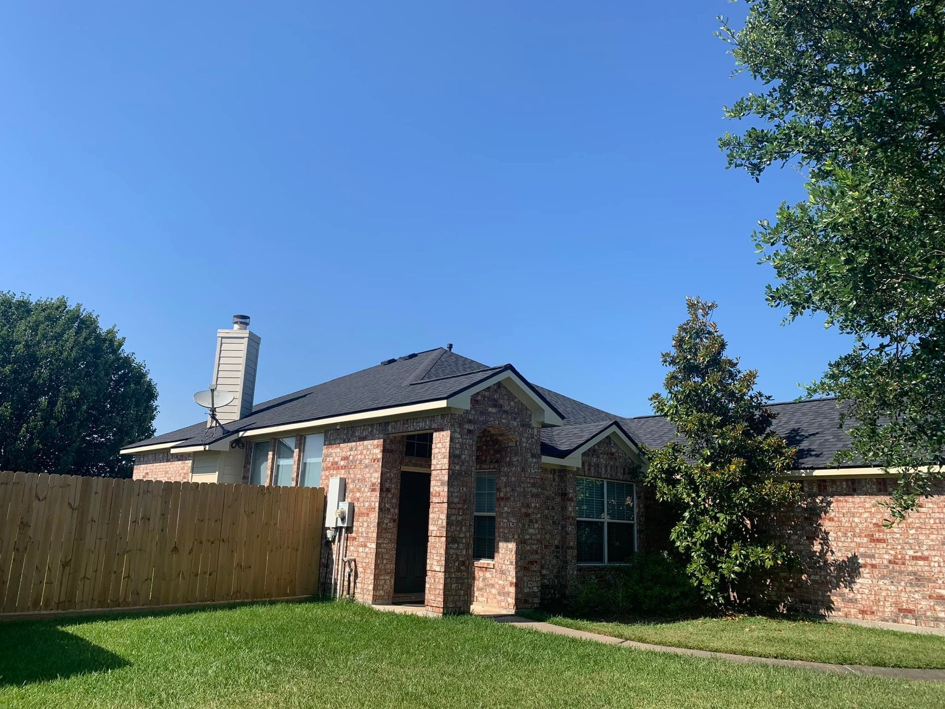 A brick house with a wooden fence in front of it.